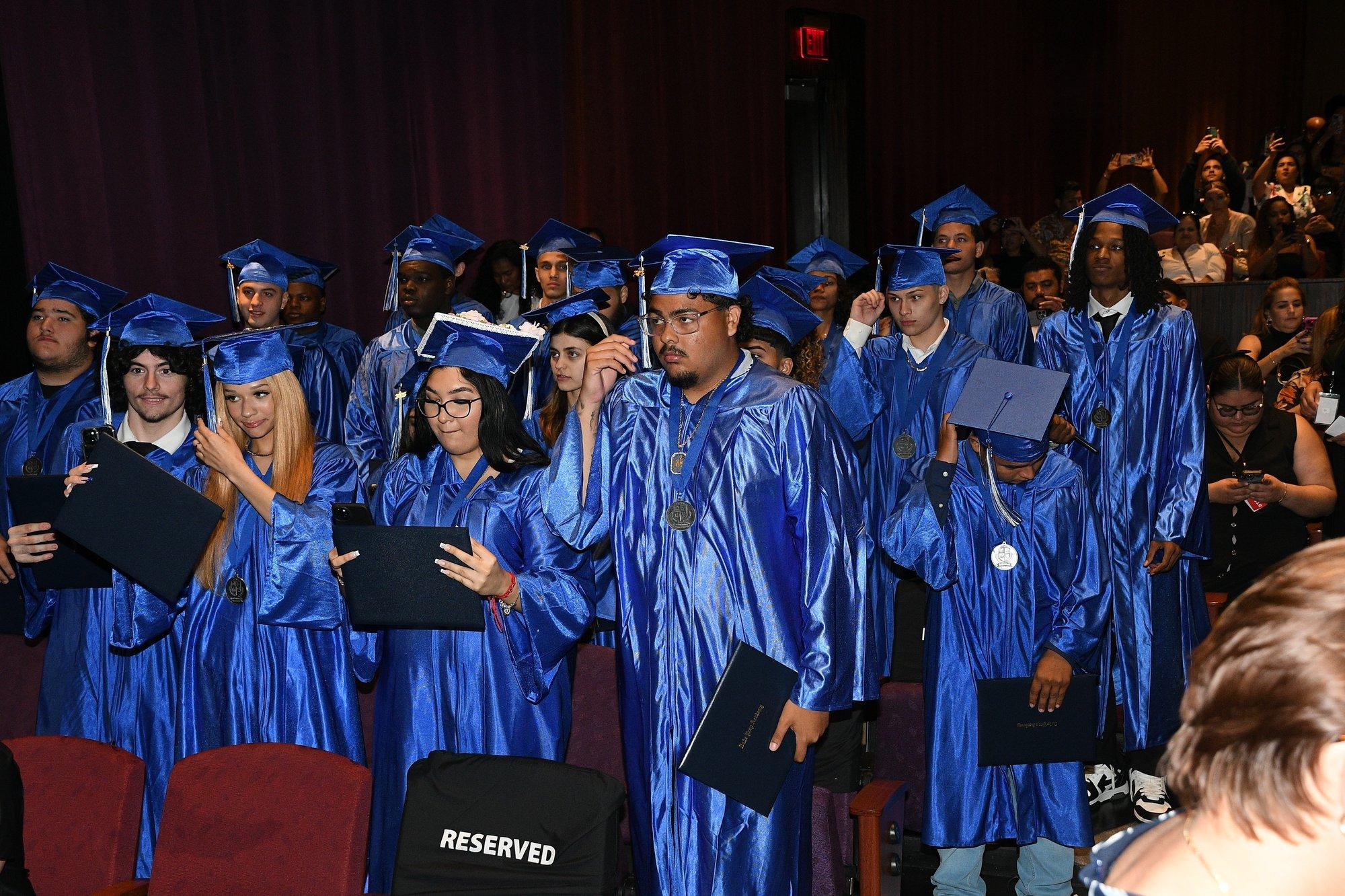 Graduates seated with their diplomas during a commencement ceremony